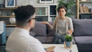 A woman and man sitting on a couch talking