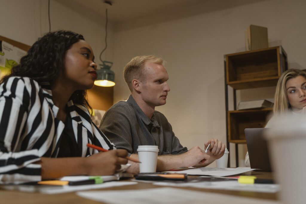 A diverse group of professionals engaged in a meeting at a modern office setting.